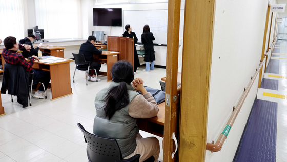 Applicants wait for their grade nine civil servant test to start on March 23 at a test site in Yongsan District, central Seoul. [MINISTRY OF PERSONNEL MANAGEMENT]