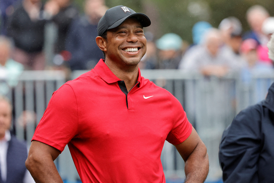 Tiger Woods smiles before he plays his shot from the first tee during the PNC Championship at The Ritz-Carlton Golf Club on December 17, 2023. [REUTERS/YONHAP]