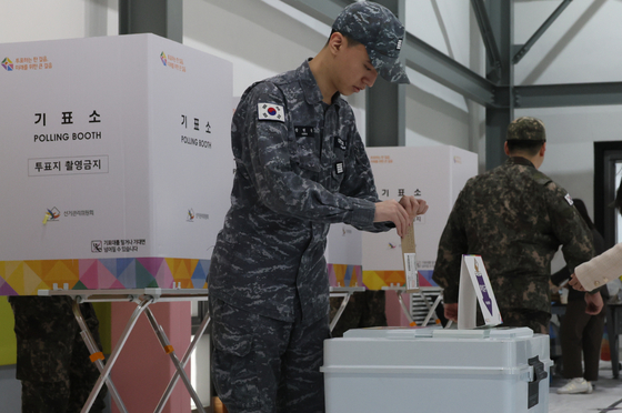 A soldier from the Korean Navy casts his ballot in the general election at a polling station in Busan on Friday. [SONG BONG-GEUN]