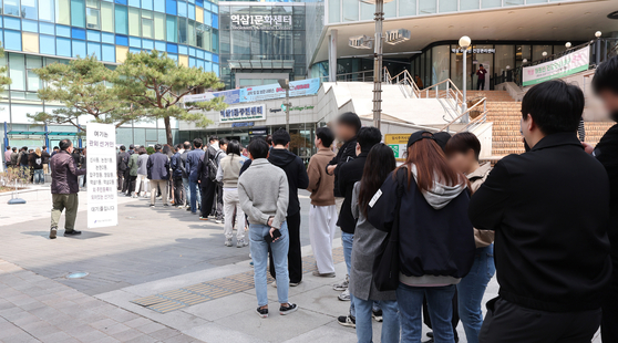Early voters wait in a long queue in front of a polling station at a community center in Yeoksam-dong in Gangnam District, southern Seoul, on Friday afternoon. [YONHAP]