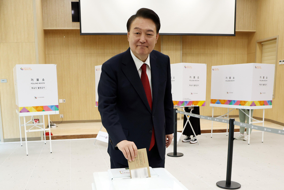 President Yoon Suk Yeol drops his vote into the ballot box at a polling station at a welfare center in Gangseo District, Busan on Friday. [JOINT PRESS CORPS]