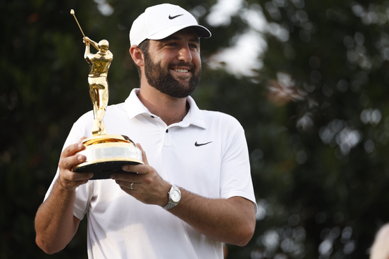 Scottie Scheffler of the United States poses with the Players Championship trophy after putting in to win on the 18th hole for his second consecutive tournament win at the Stadium Course at TPC Sawgrass on March 17 in Ponte Vedra Beach, Florida. [GETTY IMAGES]
