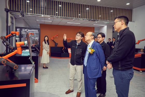 Hanwha Group Chairman Kim Seung-youn, center, inspects robots at Hanwha Robotics' headquarters in Seongnam, Gyeonggi, on Friday. [HANWHA] 