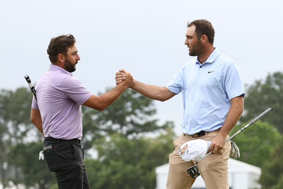 Stephan Jaeger of Germany and Scottie Scheffler of the United States shake hands on the 18th green during the final round of the Texas Children's Houston Open at Memorial Park Golf Course on March 31 Houston, Texas. [GETTY IMAGES]