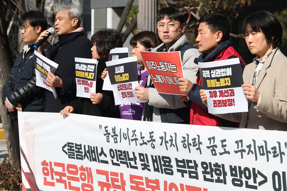 Members of the Korean Public Service and Transport Workers’ Union protest the Bank of Korea (BOK) March report that proposed solutions aiming to lower the cost of domestic workers in front of the BOK office in central Seoul on March 13. [NEWS1] 