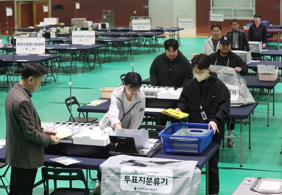 National Election Commission officials set up vote counting stations inside a gymnasium in Suwon, Gyeonggi, on Monday, two days before the April 10 general election. [NEWS1]
