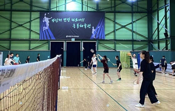 Members take turns practicing badminton at a gym. [ECOCK] 