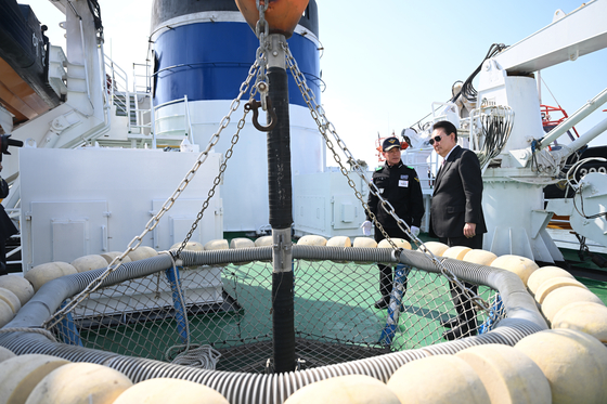 President Yoon Suk Yeol, right, inspects devices on the Korean Coast Guard's patrol vessel in Incheon on Tuesday. [PRESIDENTIAL OFFICE]