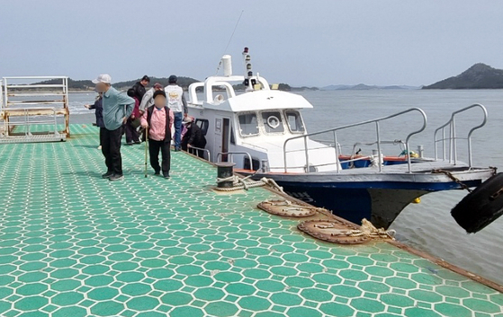 Residents of Jangbyeongdo, an island off of Sinan-gun in North Jeolla, arrive via boat in Sinan-gun to vote in the general election on Wednesday. [YONHAP]