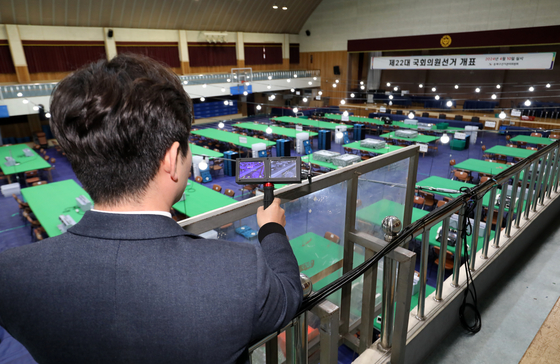A National Election Commission official inspects a polling site at a middle school in Busan with a spy camera detector on Tuesday, a day ahead of the 2024 general election. [NEWS1]