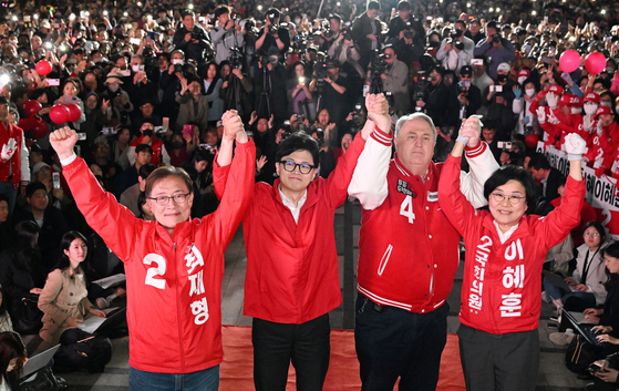 People Power Party (PPP) interim chief Han Dong-hoon, second from left, and PPP candidates hold a final campaign rally Tuesday at the Cheonggye Stream in central Seoul, on the eve of the general election. [JOINT PRESS CORPS]
