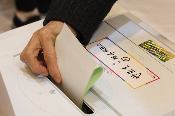 A voter submits a ballot at a polling station in Seocho District, southern Seoul, Wednesday morning to elect Korea’s next parliament. [NEWS1]