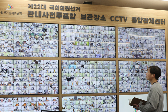 An official at the National Election Commission's headquarters in Gwacheon, Gyeonggi, monitors CCTV footage of ballot boxes used in early voting that are being stored in various locations on Sunday. [YONHAP]