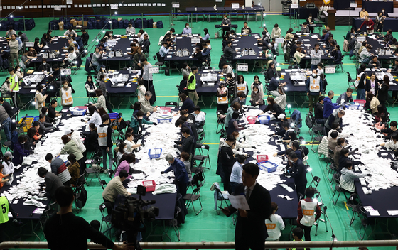 Election staffers tally ballots at a counting station set up at a gymnasium at Seoul National University in Gwanak District, southern Seoul, Wednesday evening after polls closed for Korea’s parliamentary elections. [YONHAP]