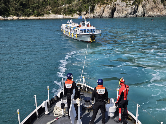 The Coast Guard helps transport six voters stranded on a 29-ton cruise ship near Ogok Island off the coast of Tongyeong, South Gyeongsang, to a polling station on another island Wednesday. [COAST GUARD]