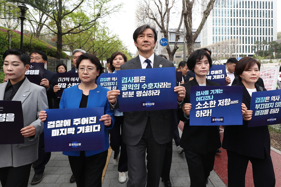 Rebuilding Korea Party leader Cho Kuk, center, and party members who won proportional representative seats on Thursday walk near the Supreme Prosecutors' Office in Seocho District, southern Seoul, holding signs demanding the prosecution summon and investigate first lady Kim Keon Hee. The demonstration followed a press conference in which the party gave a ″last warning″ to prosecutors. [NEWS1] 