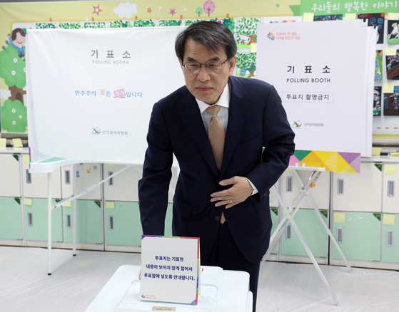 Roh Tae-ak, head the National Election Commission, casts his ballot at a polling station at an elementary school in Bangbaebon-dong in Seocho District, southern Seoul, Wednesday morning. [NEWS1]