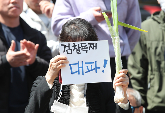 A person holds up green onions and a poster during a visit to Daegu by Former Justice Minister Cho Kuk of the Rebuilding Korea Party on Thursday, the day before election day. [NEWS1[