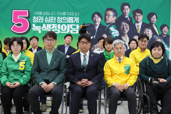 People in the leadership positions of the Justice Party watch the exit poll results on Wednesday at the National Assembly. [YONHAP] 