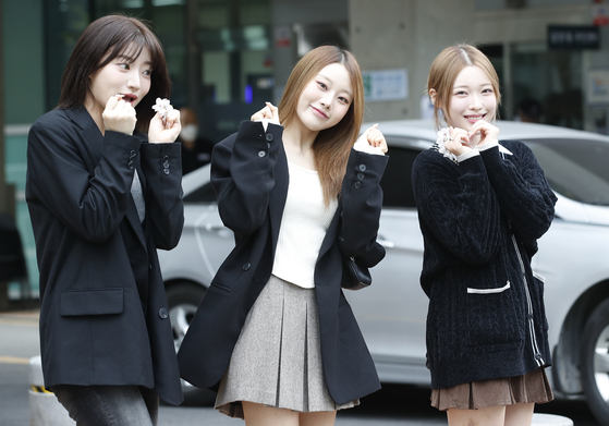 Three members of girl group Billlie pose for photos after voting for the general election on April 5. [IST ENTERTAINMENT]