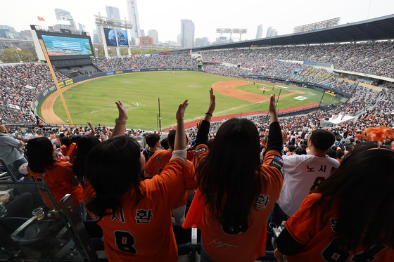 Spectators cheer during a baseball match between the Hanwha Eagles and the Doosan Bears at Jamsil Baseball Stadium in southern Seoul on Wednesday. [YONHAP] 