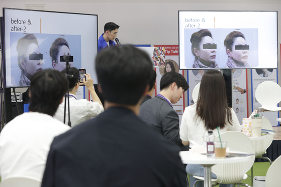 Participants at a beauty convention held at the aT center in Seocho District in southern Seoul attend a lecture on cosmetic surgery and laser on Sunday. [YONHAP]