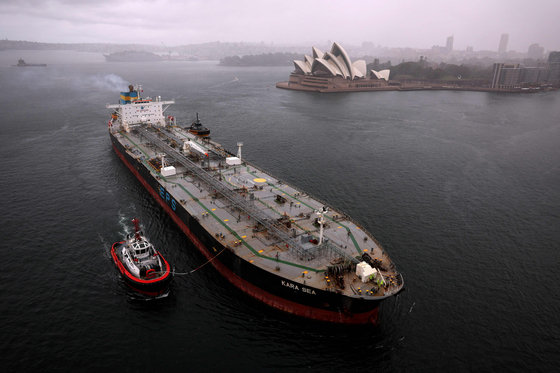 A tugboat escorts a crude oil tanker, Kara Sea, in front of the Australia‘s iconic landmark Opera House in Sydney on April 4, 2024. [Photo by Saeed KHAN/AFP]