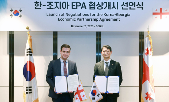 Former Trade Minister Ahn Duk-geun, right, poses for a photo with his Georgian counterpart, Genadi Arveladze, after holding a ceremony to announce the launch of talks for the Economic Partnership Agreement in Seoul on Nov. 2, 2023. [YONHAP]