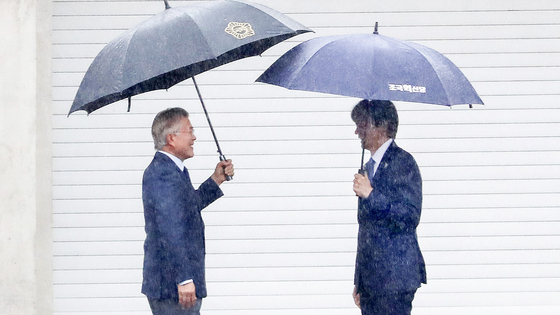 Former President Moon Jae-in, left, greets Cho Kuk, the leader of the liberal Rebuilding Korea Party, in front of his residence in Pyeongsan Village in Yangsan, South Gyeongsang, on Monday. [NEWS1]