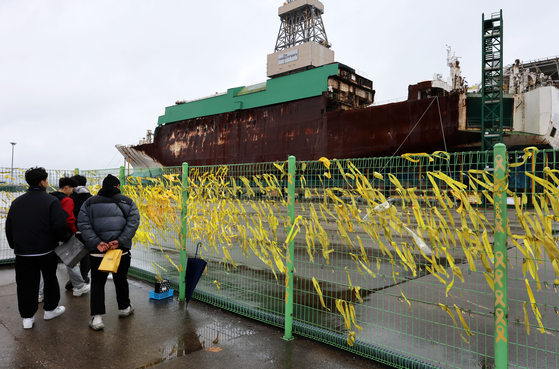 Visitors look at the Sewol ferry docked at Mokpo New Port in South Jeolla on Monday, a day ahead of the 10th anniversary of the Sewol ferry tragedy. [YONHAP] 