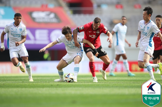 The Pohang Steelers' Shin Kwang-hoon, center left, vies for the ball with FC Seoul's Stanislav Iljutcenko during a K League 1 match at Seoul World Cup Stadium in western Seoul on Saturday. [YONHAP] 