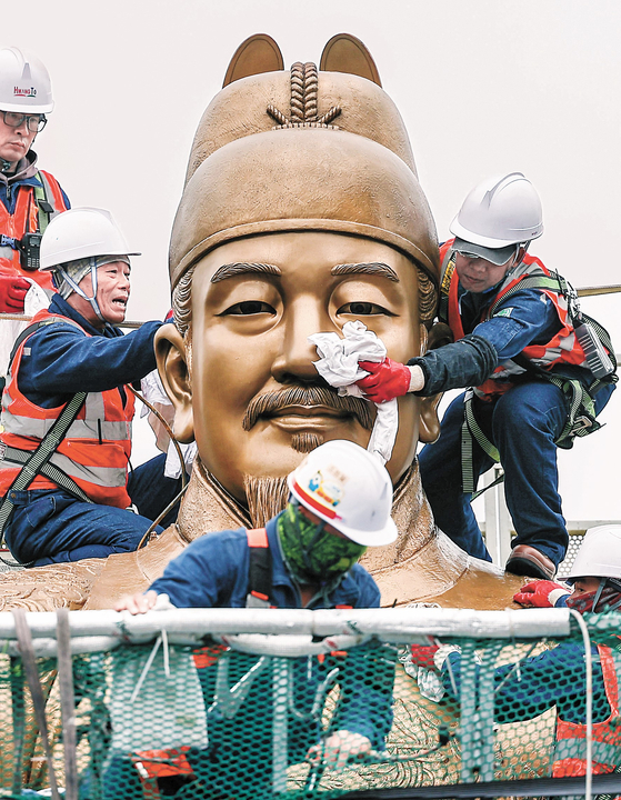 Seoul officials are cleaning off the dust using cloths on the statue of King Sejong in central Seoul. [JOINT PRESS CORPS]