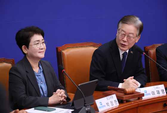 Park Jeong-hyun, left, member of the DP’s supreme council, sits next to Democratic Party leader Lee Jae-myung on Nov. 3 at the National Assembly in western Seoul. [YONHAP] 