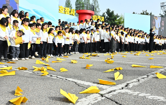 Yellow paper planes thrown by members of a choir land on the ground during a remembrance service for the victims of the Sewol ferry tragedy at Hwarang Public Garden in Ansan, Gyeonggi, on Tuesday, which marked the 10th anniversary of the tragedy. [JOINT PRESS CORPS]
