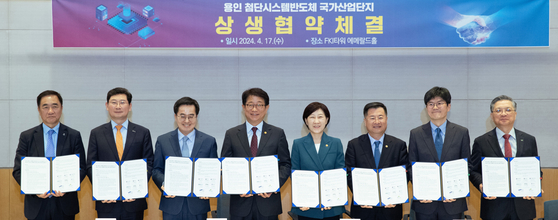 Attendees at the agreement signing ceremony for the advanced industrial chip complex in Yongin, including Land Minister Park Sang-woo, fourth from left, and Samsung Electronics President Nam Seok-woo, second from right, pose for a photo at FKI Tower in Yeouido, western Seoul, on Wednesday. [NEWS1]