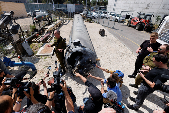 An Israeli military spokesperson speaks to the media Tuesday as Israel's military displays what they say is an Iranian ballistic missile, which they retrieved from the Dead Sea after Iran launched drones and missiles towards Israel last Saturday. [REUTERS/YONHAP]