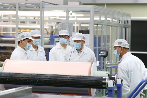 Lotte Chairman Shin Dong-bin, second from right, inspects finished cathode products at Lotte Energy Materials' factory in Malaysia. [LOTTE CORPORATION]