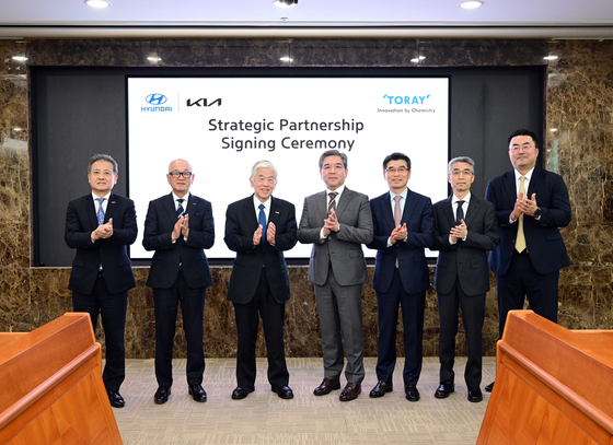 Executives from Hyundai Motor Group and Toray Industries including Akihiro Nikkaku, third from left, chairman of Toray, Chang Jae-hoon, fourth from left, CEO of Hyundai Motor, and Song Ho-sung, fifth from left, CEO of Kia, take a photo after signing an agreement at Hyundai's headquarters in Yangje-dong, southern Seoul. [HYUNDAI MOTOR] 