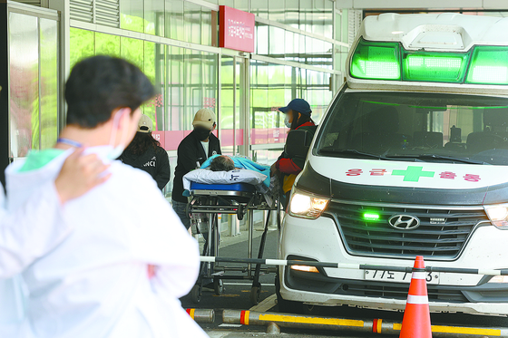 Rescue workers transport a patient at a university hospital in Seoul as mass walkout of medical trainees against the government's plan to increase the medical school admission quota continues for nearly two months. According to fire officials, a heart disease patient in her 60s living in South Gyeongsang was taken to a hospital in Busan after six nearby hospitals refused to accept her. She died six hours after she sought help through the 119 emergency rescue number. [NEWS1] 