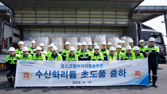 Posco-Pilbara Lithium Solution CEO Lee Kyung-sup, sixth from the left in the front row, and other executives take a photo celebrating the shipment of the first batch of lithium hydroxide at its factory in South Jeolla on April 16. [POSCO HOLDINGS]