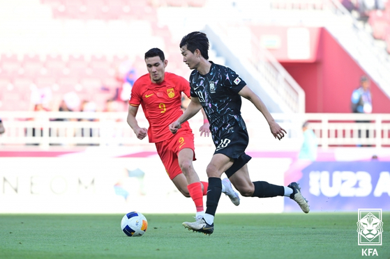Korea's Kim Min-woo, right, dribbles the ball during an AFC U-23 Asian Cup group stage match against China at Abdullah bin Khalifa Stadium in Doha, Qatar on Friday. [YONHAP] 