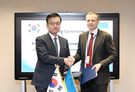 Korean Finance Minister Choi Sang-mok, left, poses for a photo with his Ukraine counterpart, Sergii Marchenko, after signing an agreement on low-interest loan programs for Ukraine in Washington on Friday. [MINISTRY OF ECONOMY AND FINANCE]