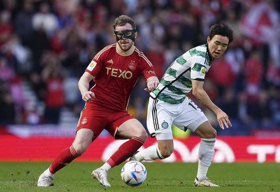 Aberdeen's Nicky Devlin, left, and Celtic's Yang Hyun-Jun battle for the ball during the Scottish Cup semifinal match between Celtic and Aberdeen at Hampden Park in Glasgow, Scotland on Saturday. [AP/YONHAP]