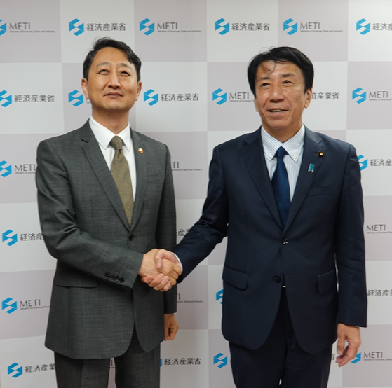 Korean Industry Minister Ahn Duk-geun, left, and his Japanese counterpart Ken Saito shake hands before a meeting in Tokyo on Monday. [YONHAP]