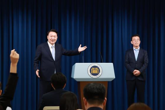 President Yoon Suk Yeol, left, introduces Hong Chul-ho, founder of the Goobne Chicken franchise, as his new senior secretary for political affairs, at the Yongsan presidential office in central Seoul in his second press encounter of the day. [JOINT PRESS CORPS]