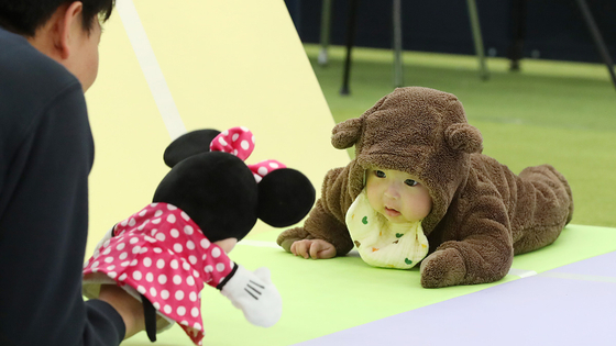 A baby in a bear outfit crawls towards their father at the Daegu Baby and Kids Fair held in Buk District, Daegu, on March 7. [NEWS1] 