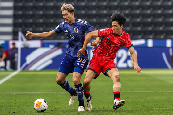 Korea's Hong Yun-sang, right, vies for the ball with Japan's Shota Fujio during an AFC U-23 Asian Cup match at Jassim Bin Hamad Stadium in Al Rayyan, Qatar on Monday. [AFP/YONHAP] 