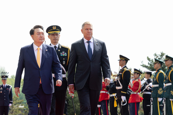 Korean President Yoon Suk Yeol, left, and his Romanian President Klaus Iohannis review an honor guard at an official welcoming ceremony ahead of their bilateral summit at the Yongsan presidential office in central Seoul on Tuesday. [PRESIDENTIAL OFFICE] 