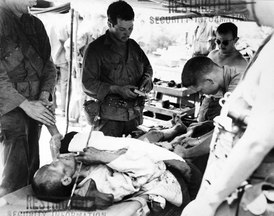 U.S. soldiers perform a non-circumcision related surgery on a Korean patient in 1950. [NATIONAL ARCHIVES AND RECORDS ADMINISTRATION]