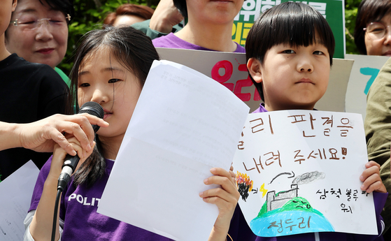 A young environmental activist calls for a speedy ruling on petitions filed against the government's inadequate response to climate change during a press conference held Tuesday in front of the Constitutional Court in central Seoul, ahead of the first public hearing about the case on the same day.  (NEWS1) 